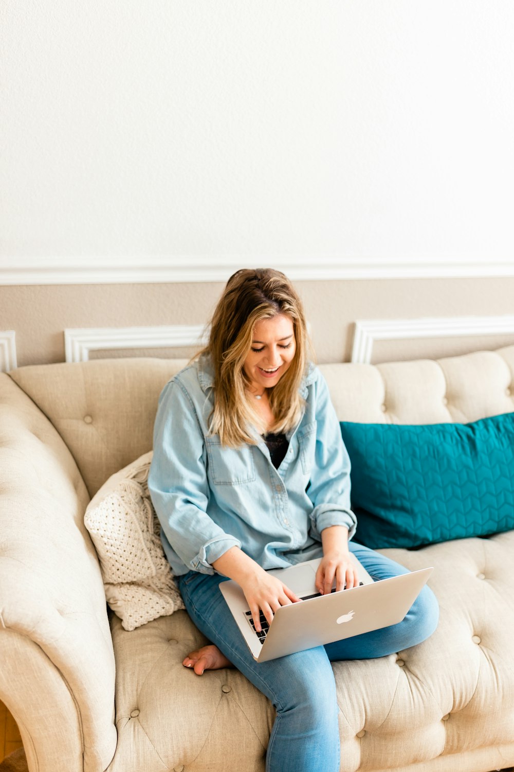 a woman sitting on a couch using a laptop computer