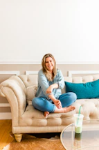 A friendly technician cleaning a bright green sofa in a cozy living room.