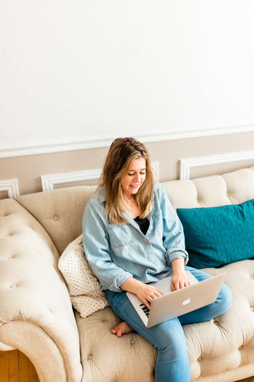 a woman sitting on a couch using a laptop