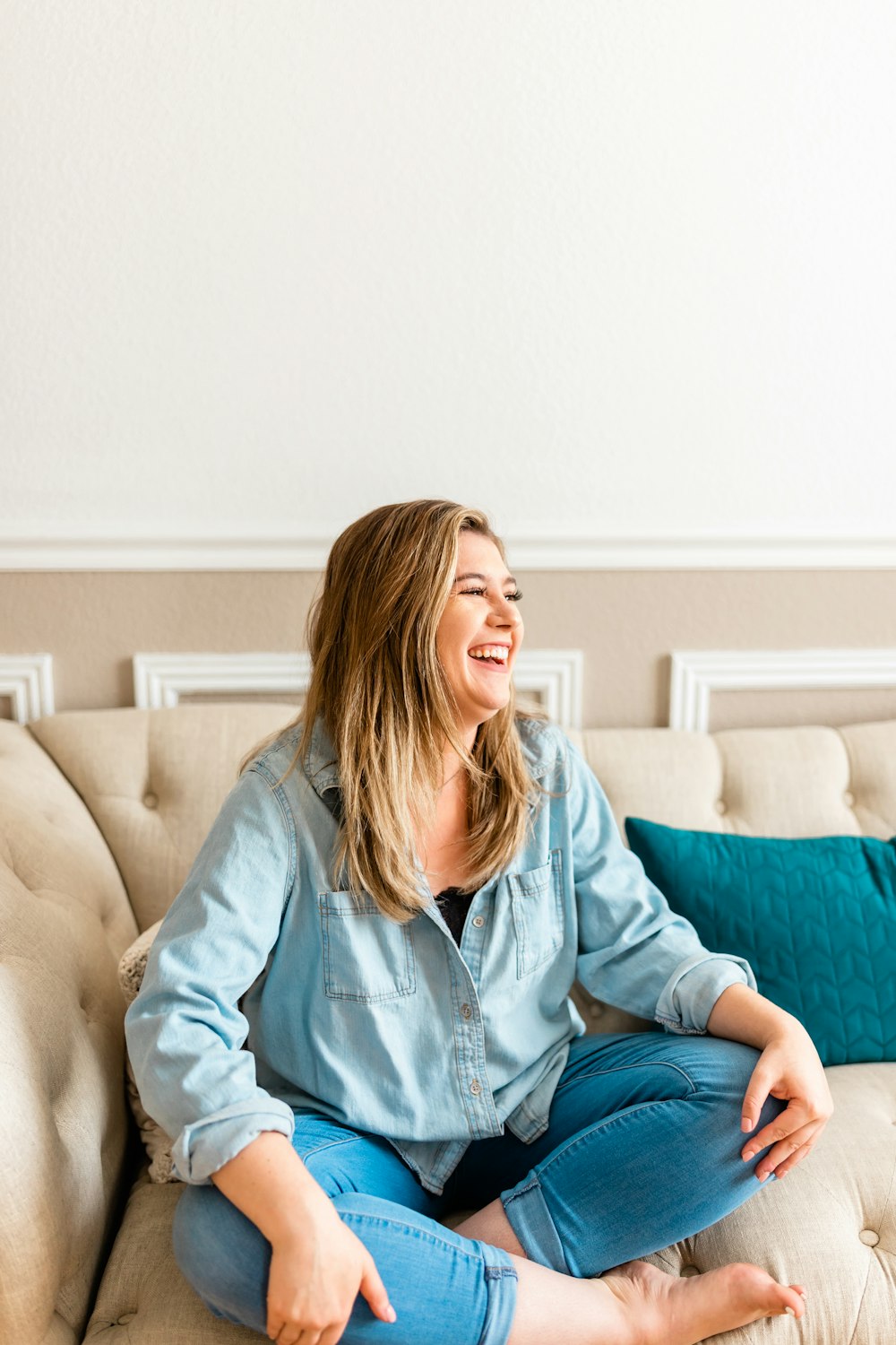 a woman sitting on top of a couch smiling