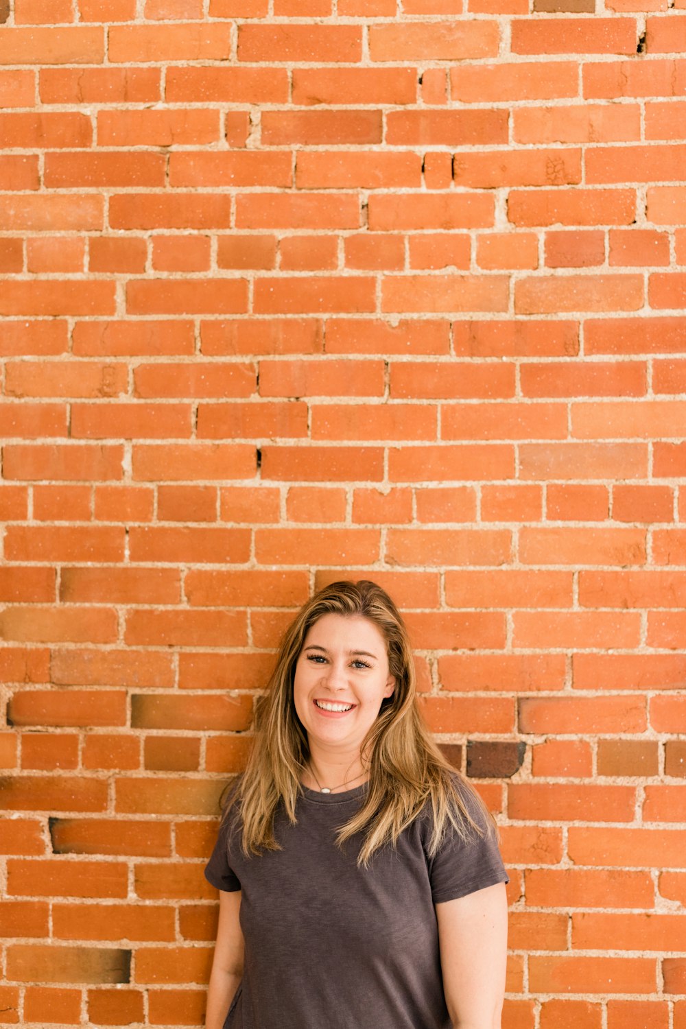 a person standing in front of a brick wall