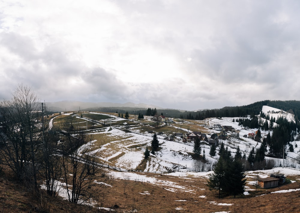 a snow covered hillside with a small village in the distance