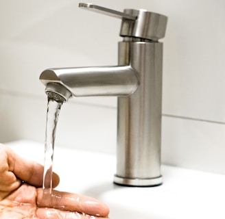 a person washing their hands under a faucet