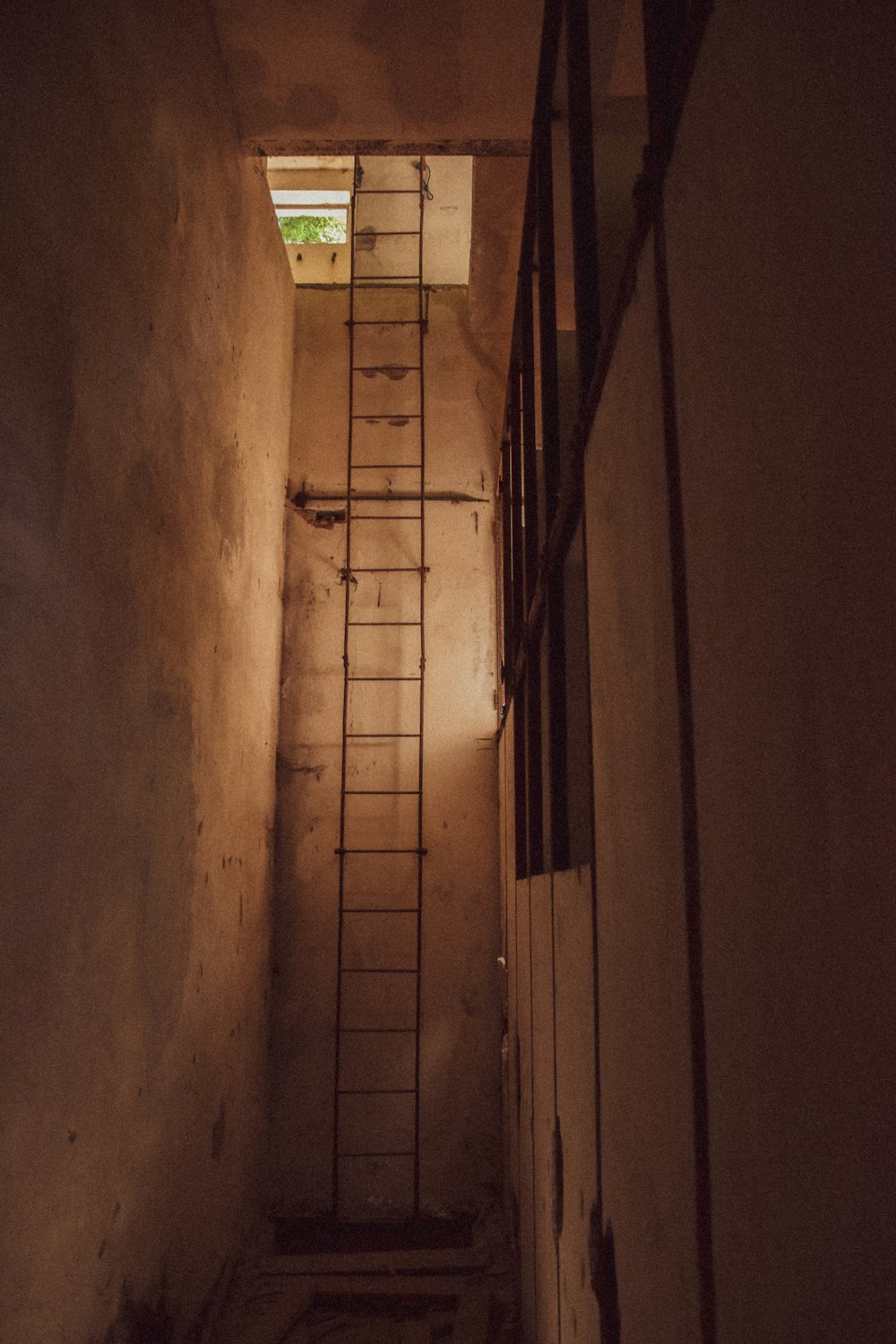 una escalera hasta una ventana en una habitación oscura