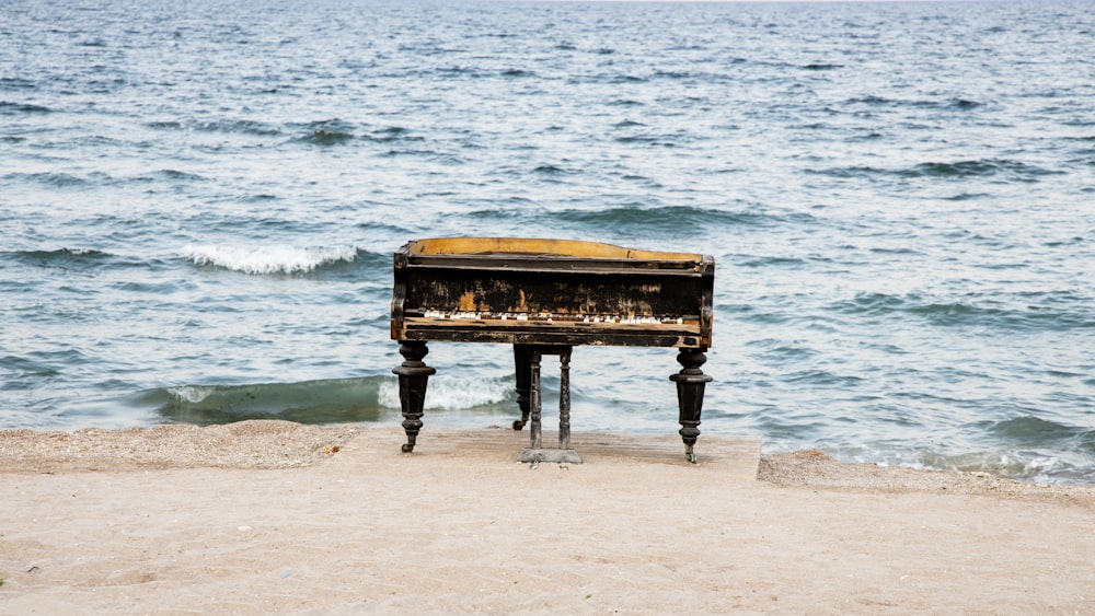 an old piano sitting on top of a sandy beach