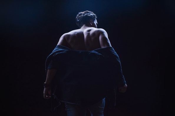 a woman walking in the dark with her back to the camera