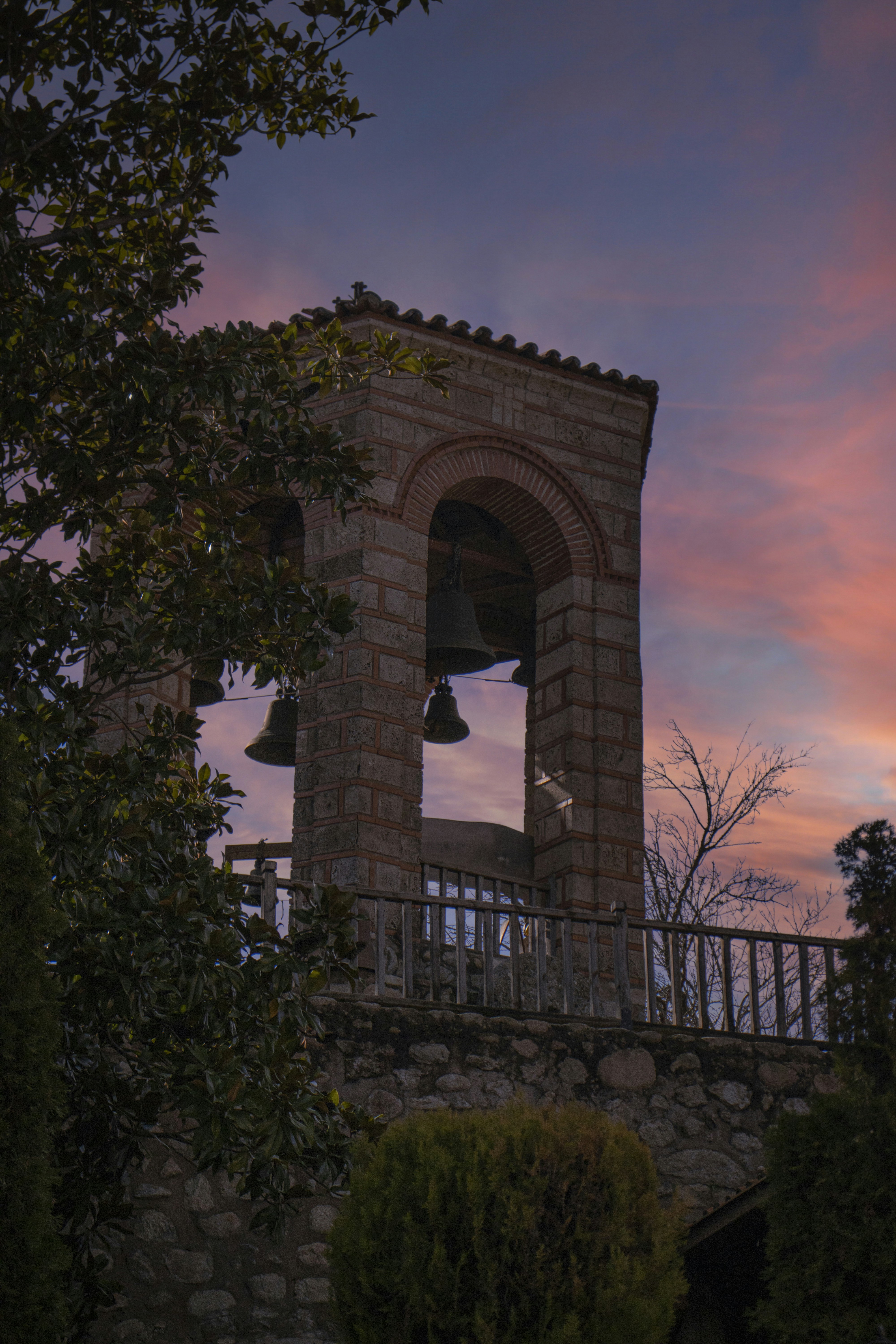 a bell tower with a sunset in the background