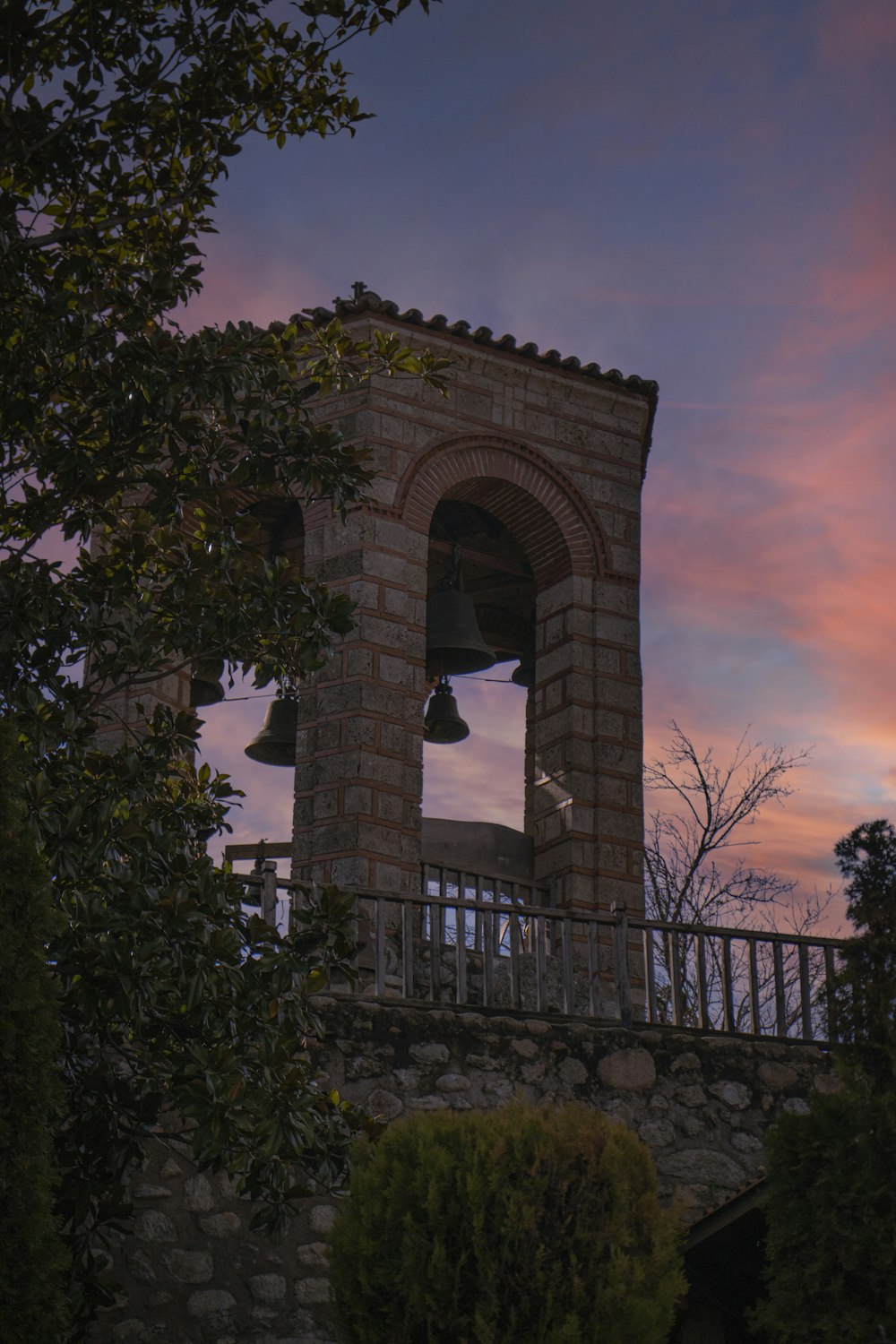 a bell tower with a sunset in the background