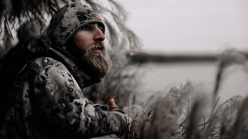 a man with a beard standing in a field