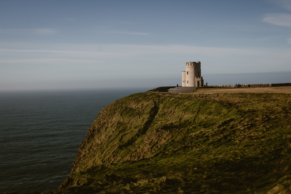 a lighthouse on a cliff overlooking the ocean