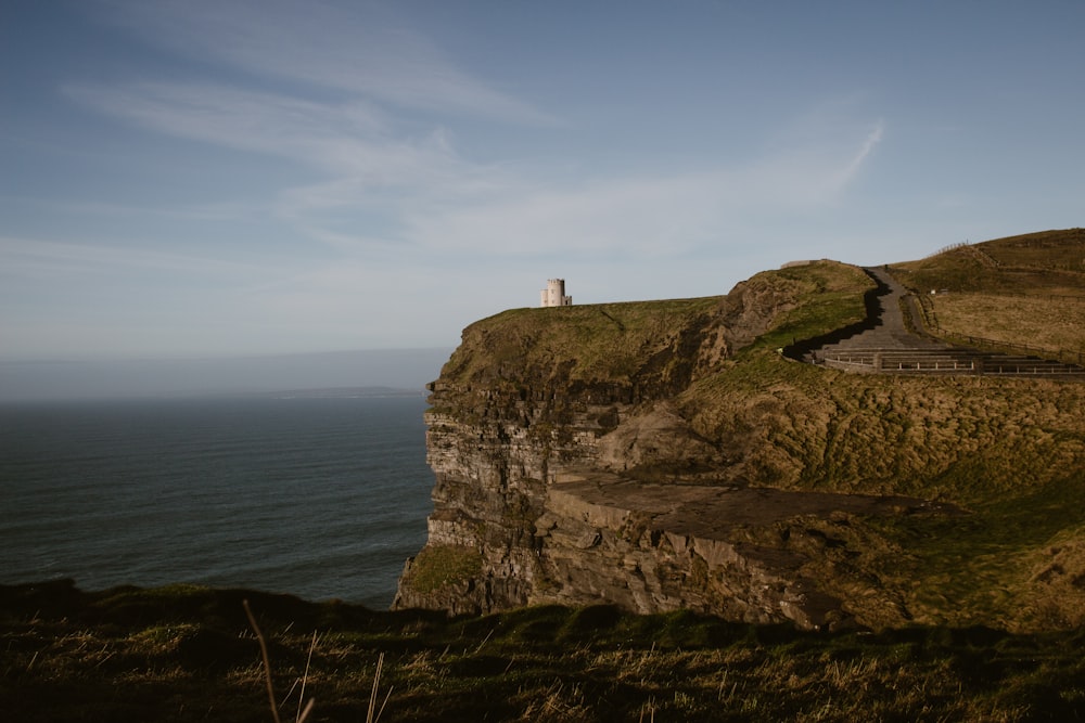 a lighthouse on a cliff overlooking the ocean