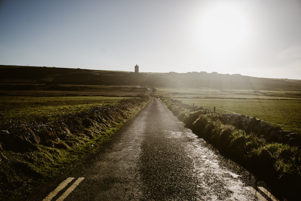 the sun shines brightly on a rural road