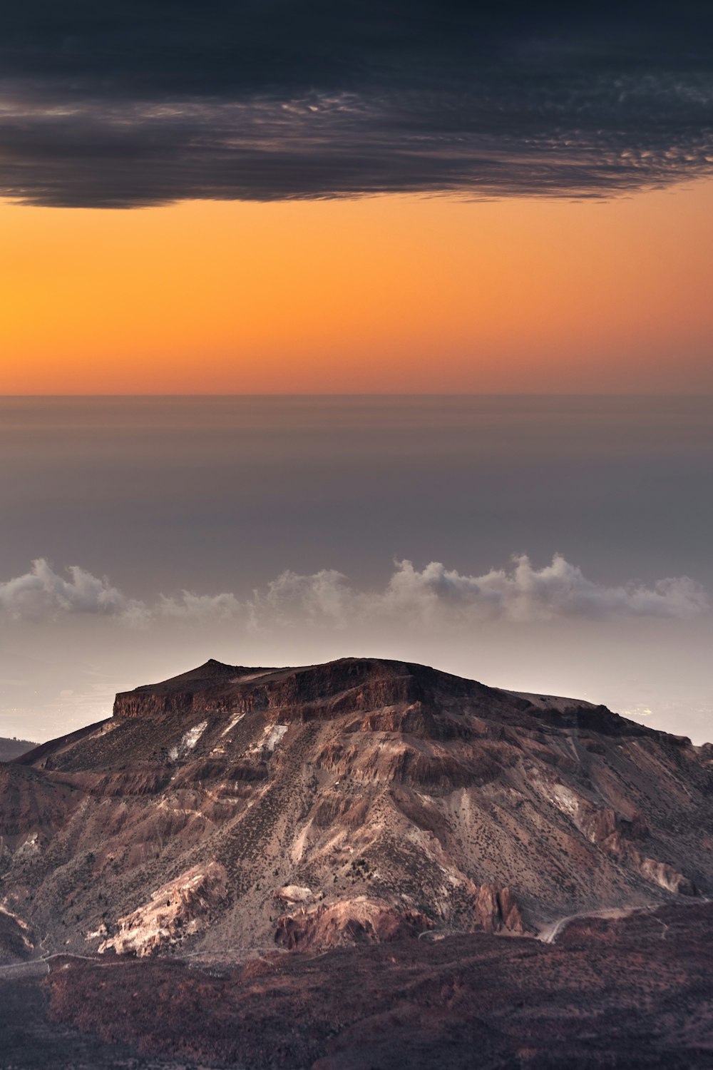 a view of a mountain with a sunset in the background