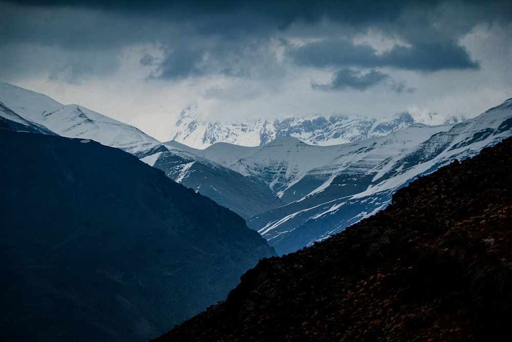 Una cadena montañosa con montañas cubiertas de nieve en la distancia