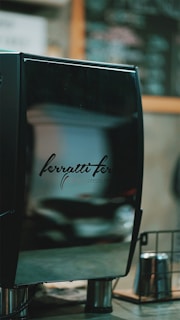 The sleek black and red exterior of the Le Four Automate machine installed in an urban setting.