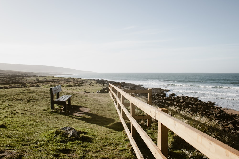 a wooden bench sitting on top of a lush green hillside