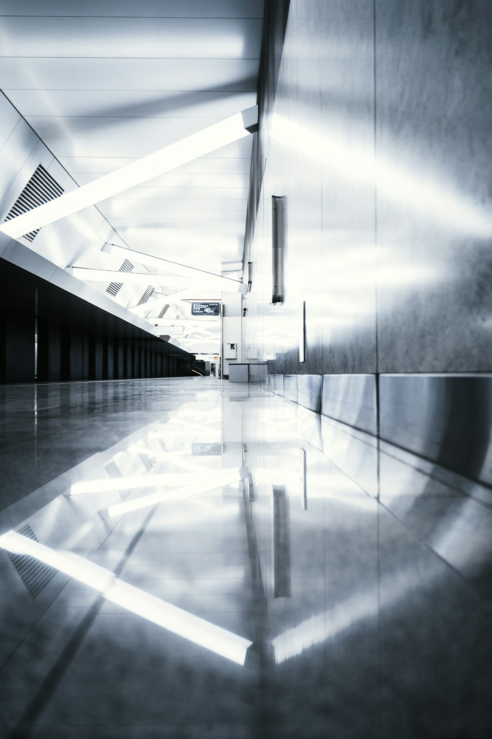 a long hallway with a light reflecting off the floor