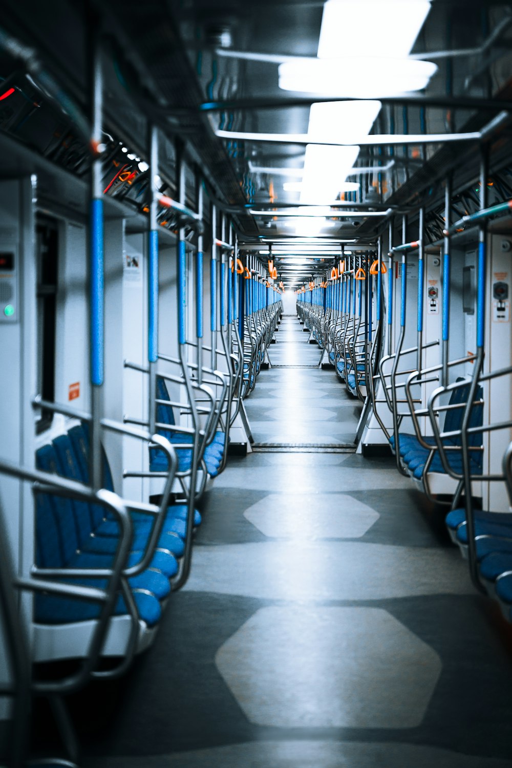 a long empty train car with blue seats