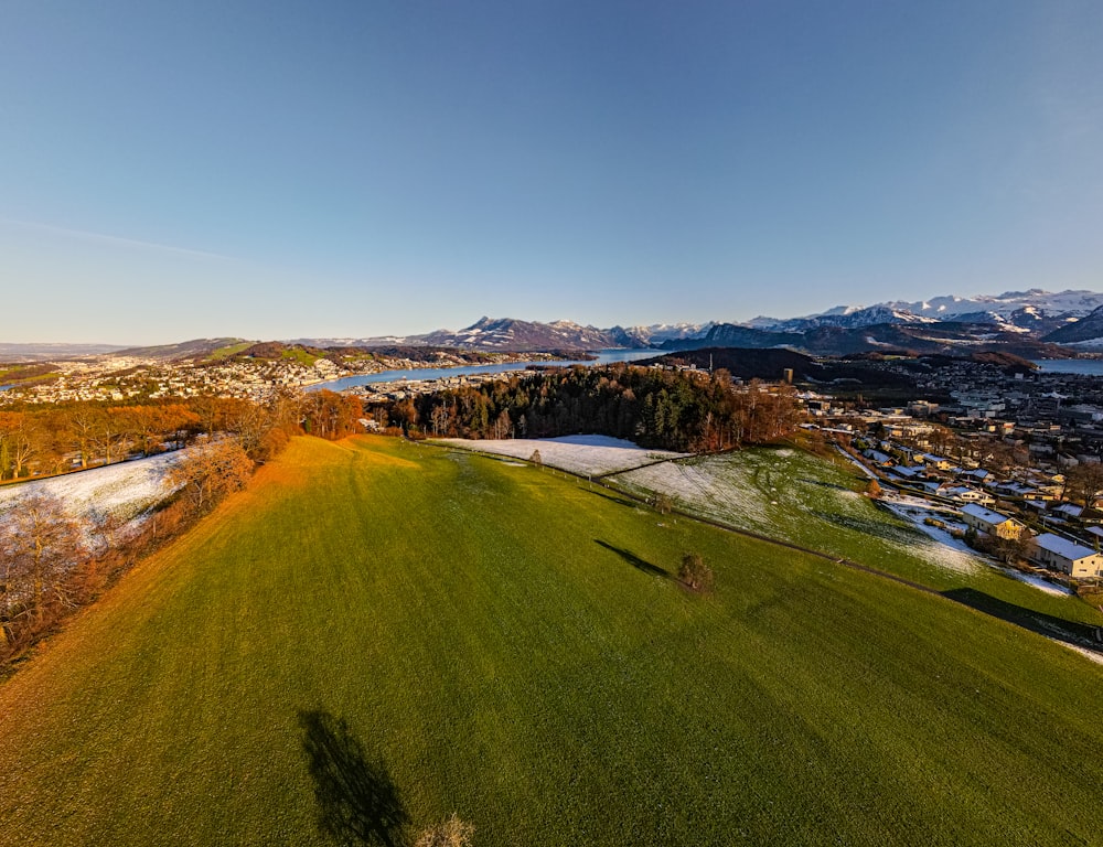 an aerial view of a golf course with a lake in the background