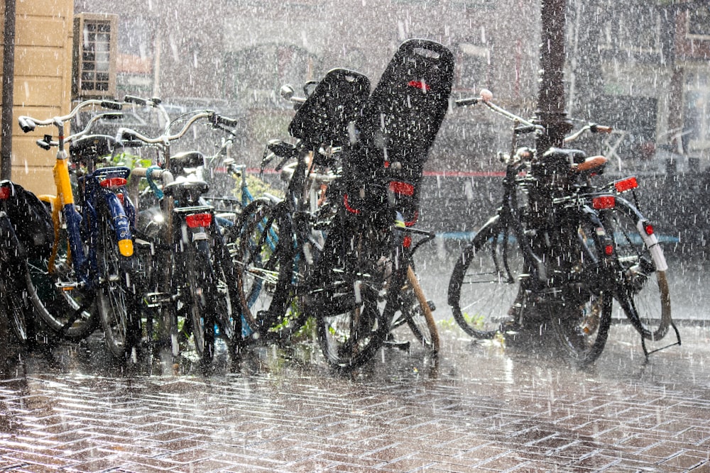 a group of bikes parked next to each other in the rain
