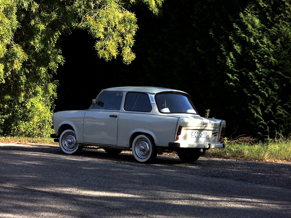 an old car is parked on the side of the road