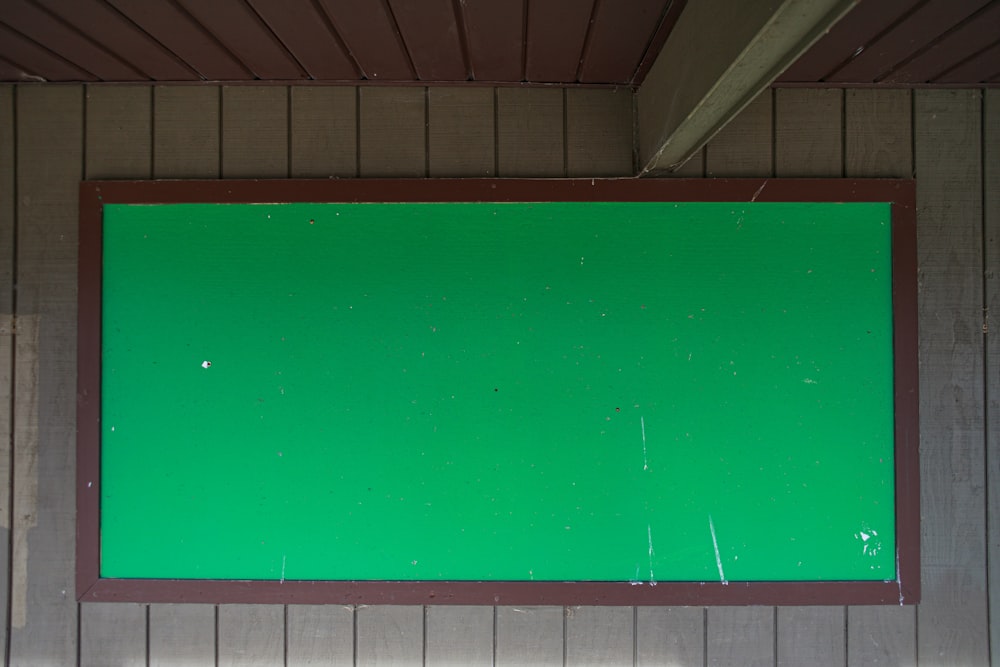 a green screen mounted to the side of a building