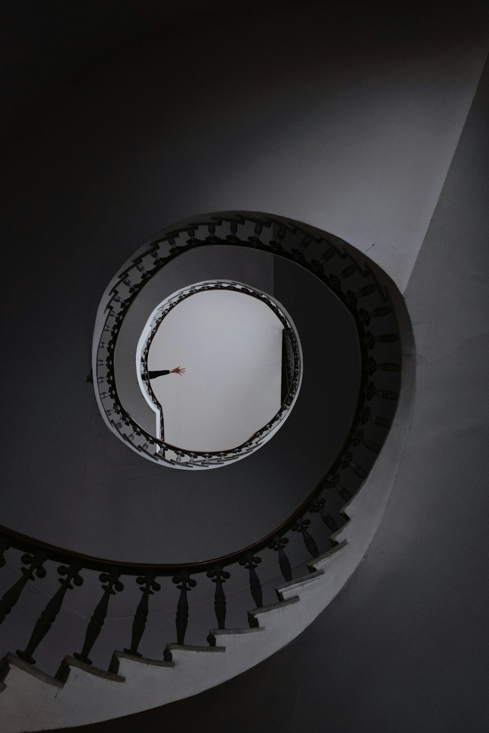a spiral staircase with a clock on the wall