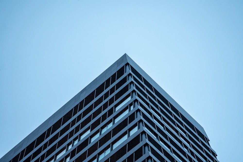 Ein hohes Gebäude mit vielen Fenstern vor blauem Himmel