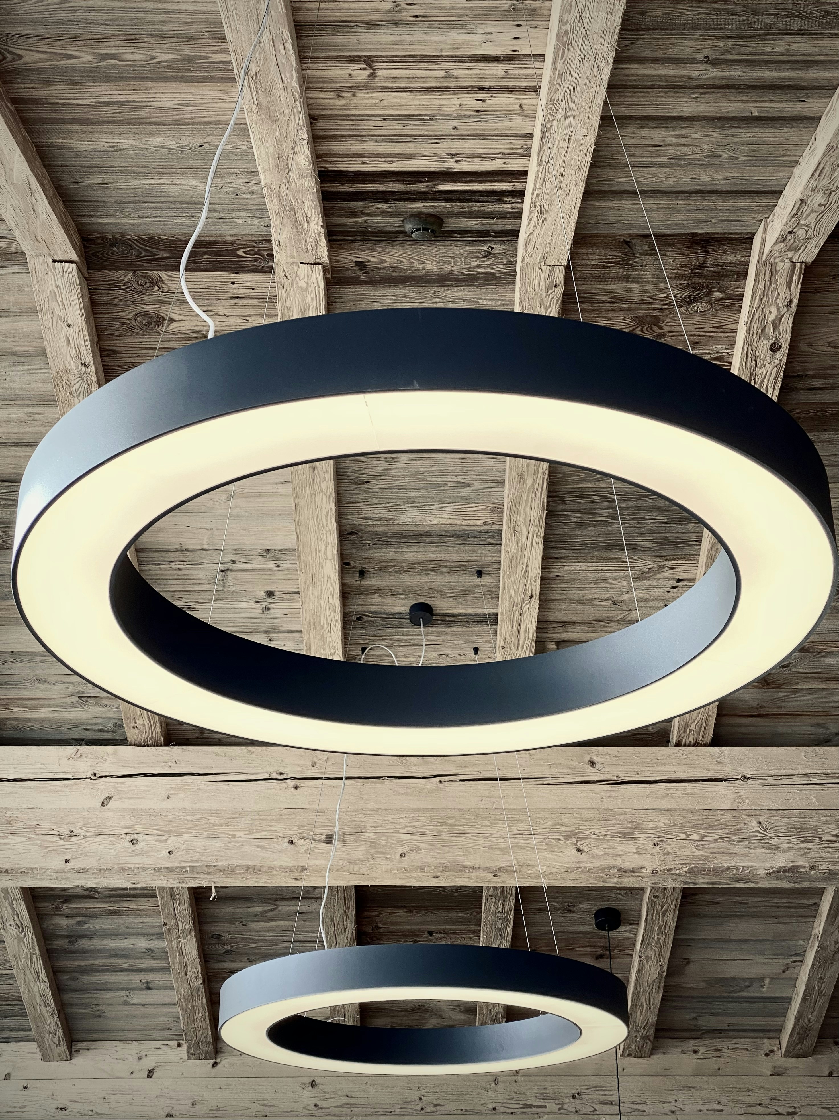 A circular light fixture hanging from a wooden ceiling photo – Free ...
