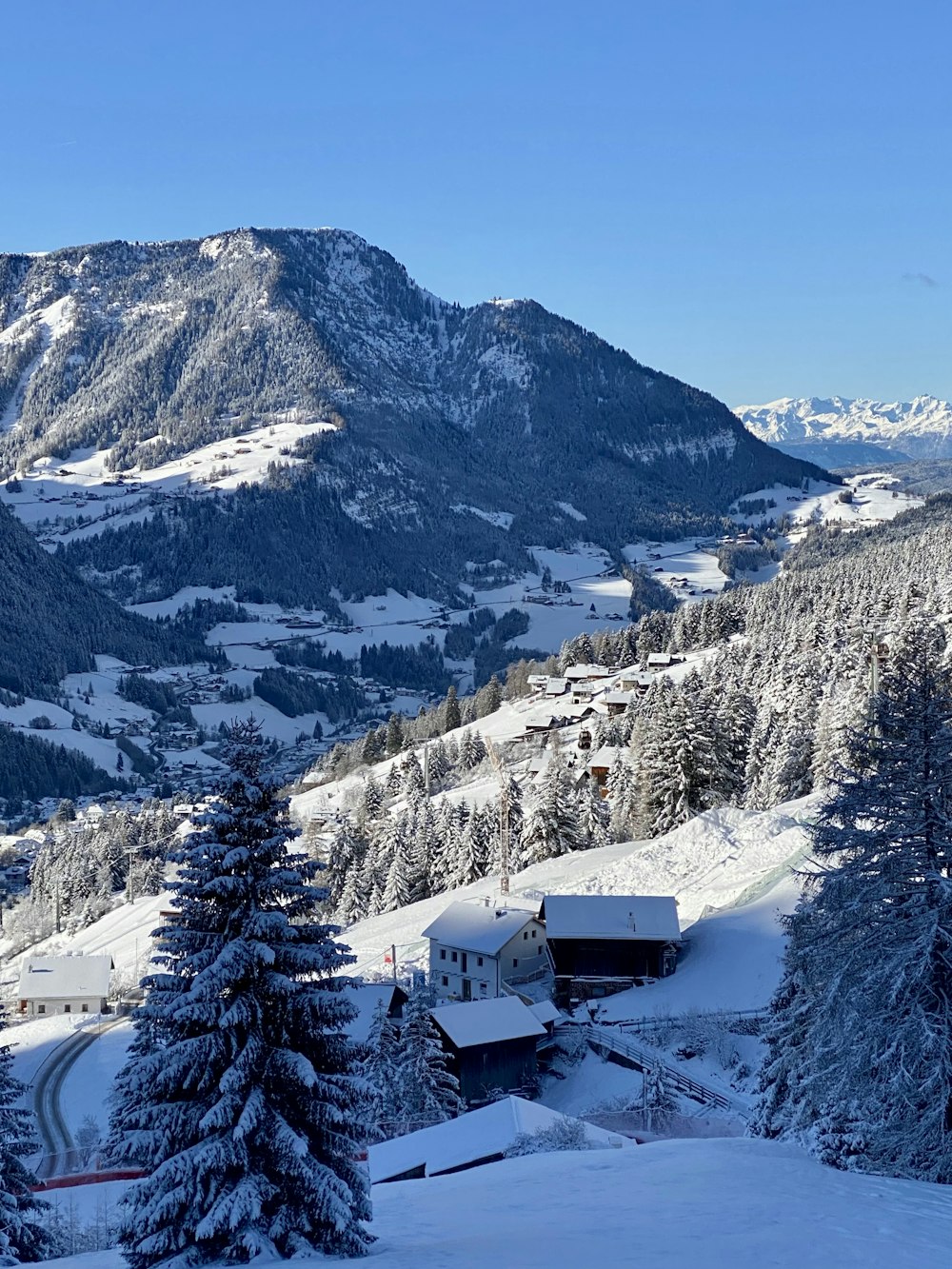 Una montagna innevata con una baita in primo piano