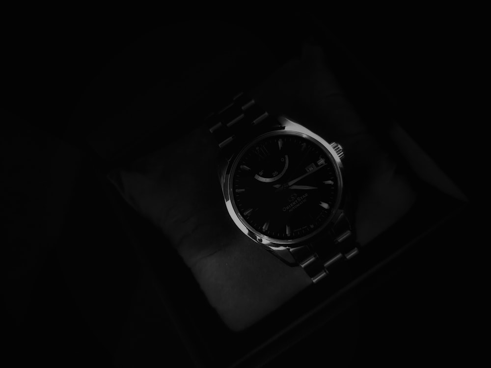 a watch sitting on top of a table in the dark