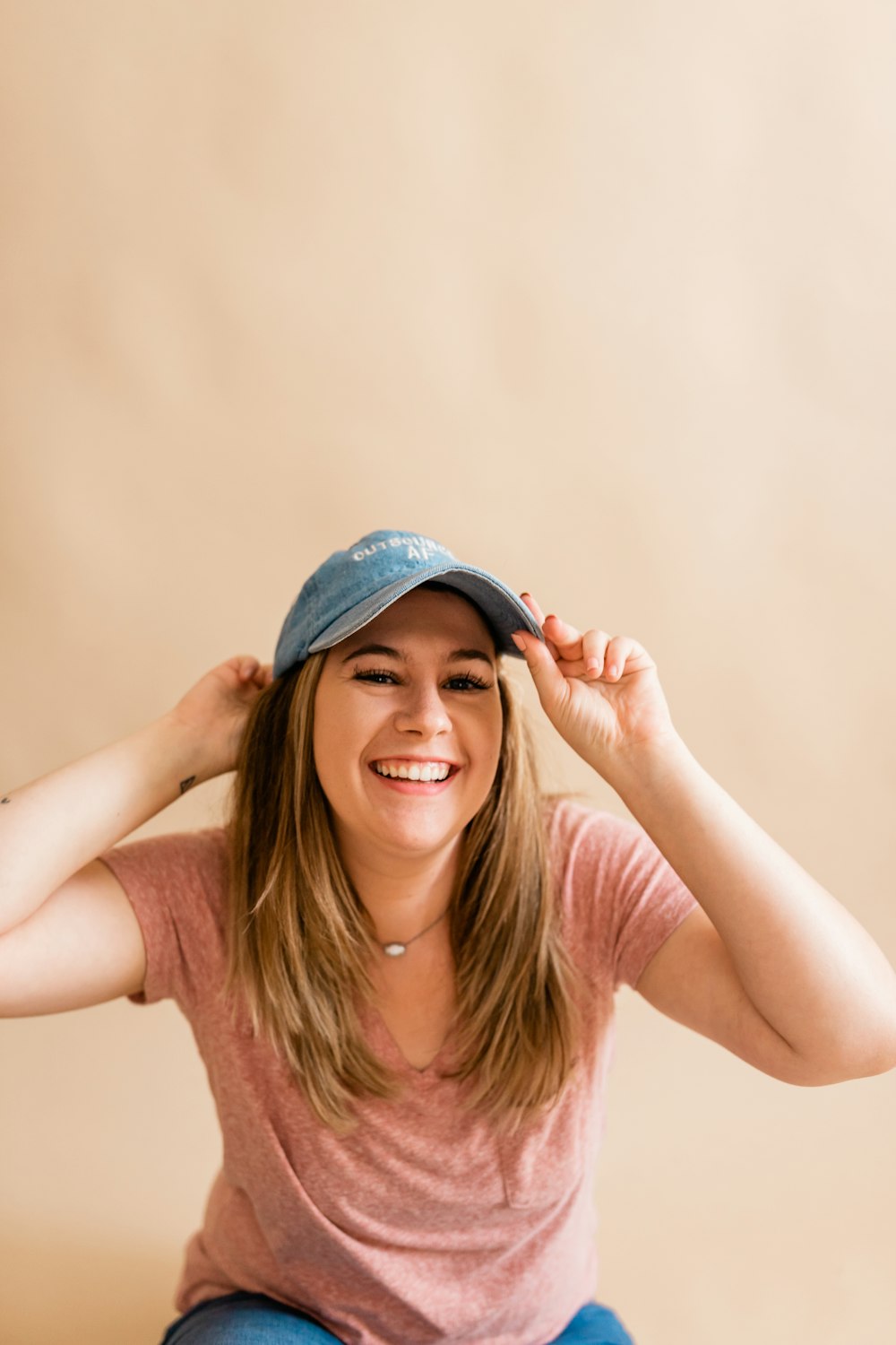 a woman sitting on the floor wearing a hat