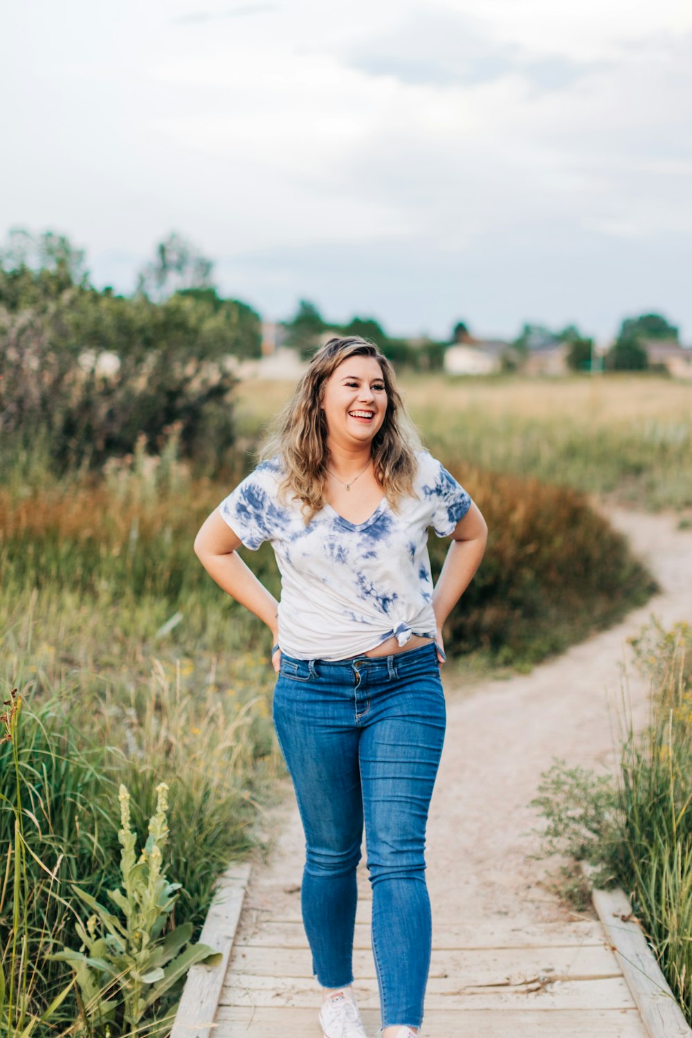 a woman standing on a path in a field