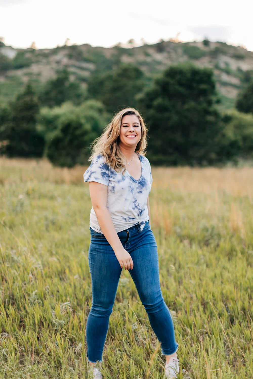 a woman standing in a field of tall grass