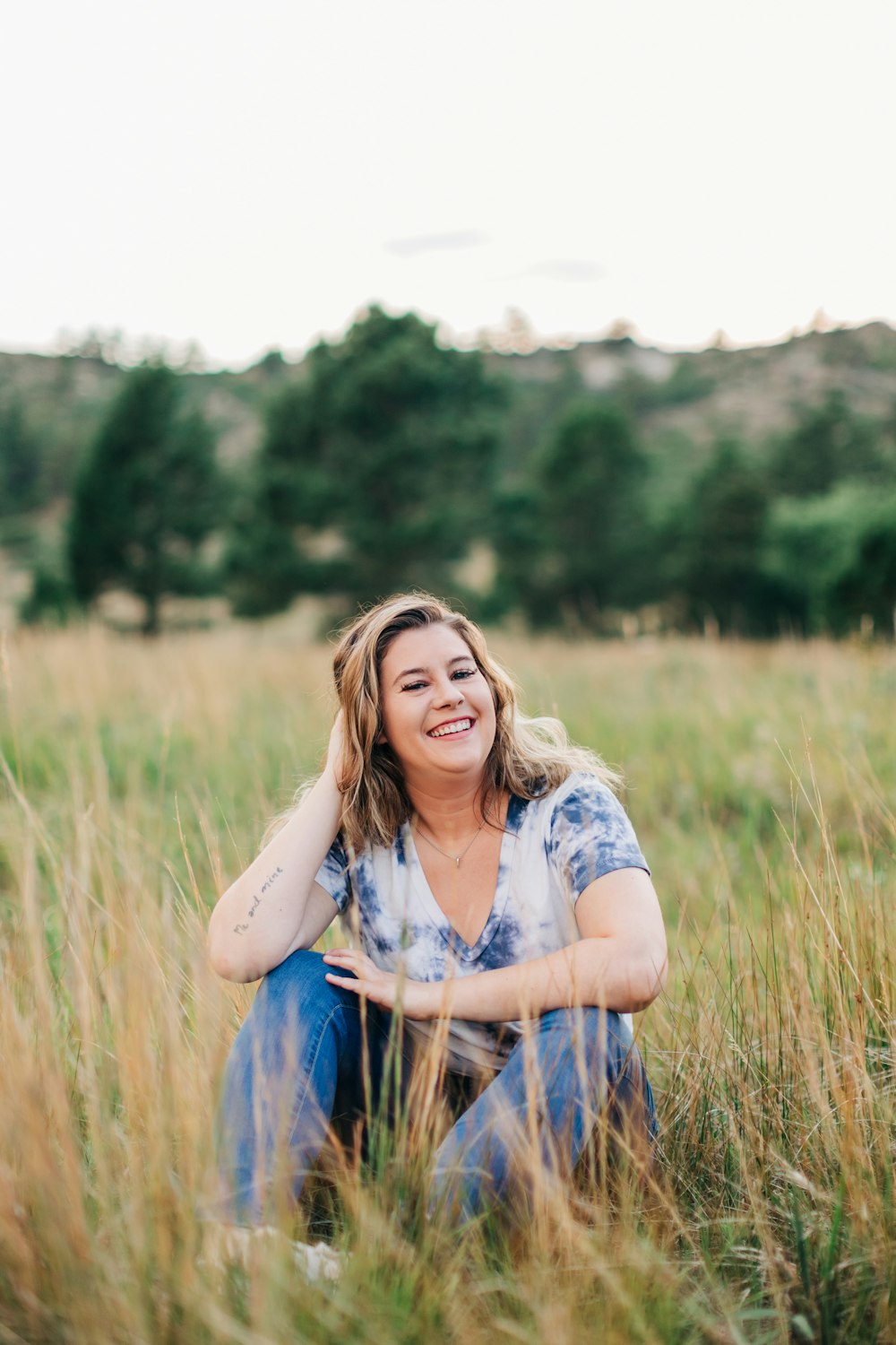 a woman sitting in a field of tall grass