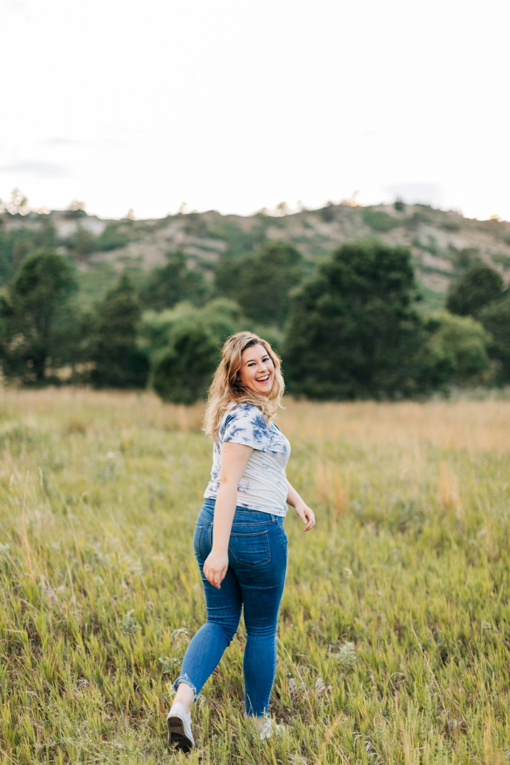 a woman standing in a field of tall grass