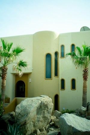 A white stucco home with palm trees and desert rock landscaping, typical of homes across the Las Vegas valley in the fall buying season