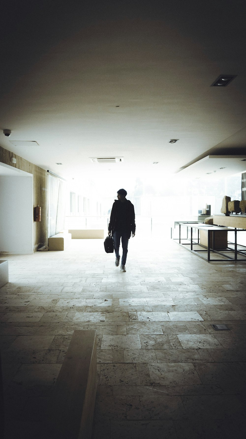a man with a suitcase walks through a dimly lit room