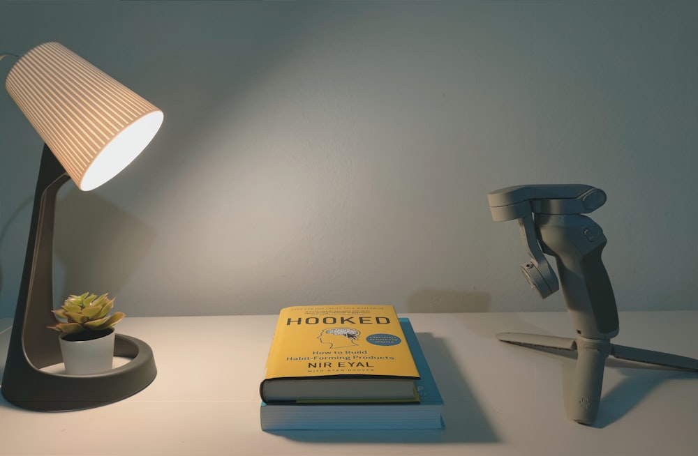 a desk with a lamp and a book on it