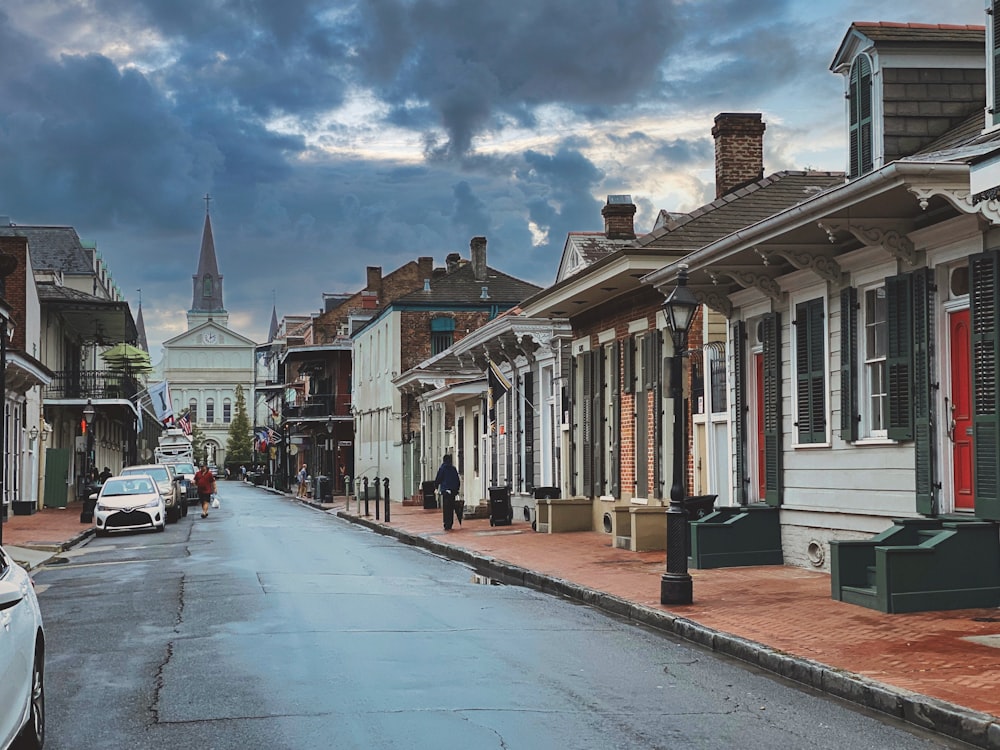 a street lined with row houses under a cloudy sky