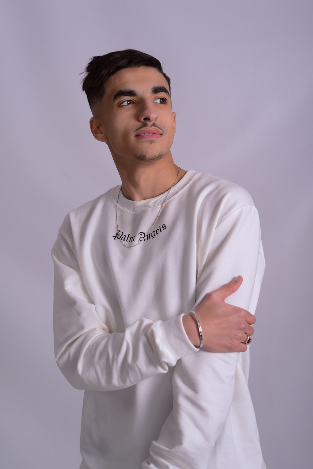 a man in a white sweatshirt posing for a picture