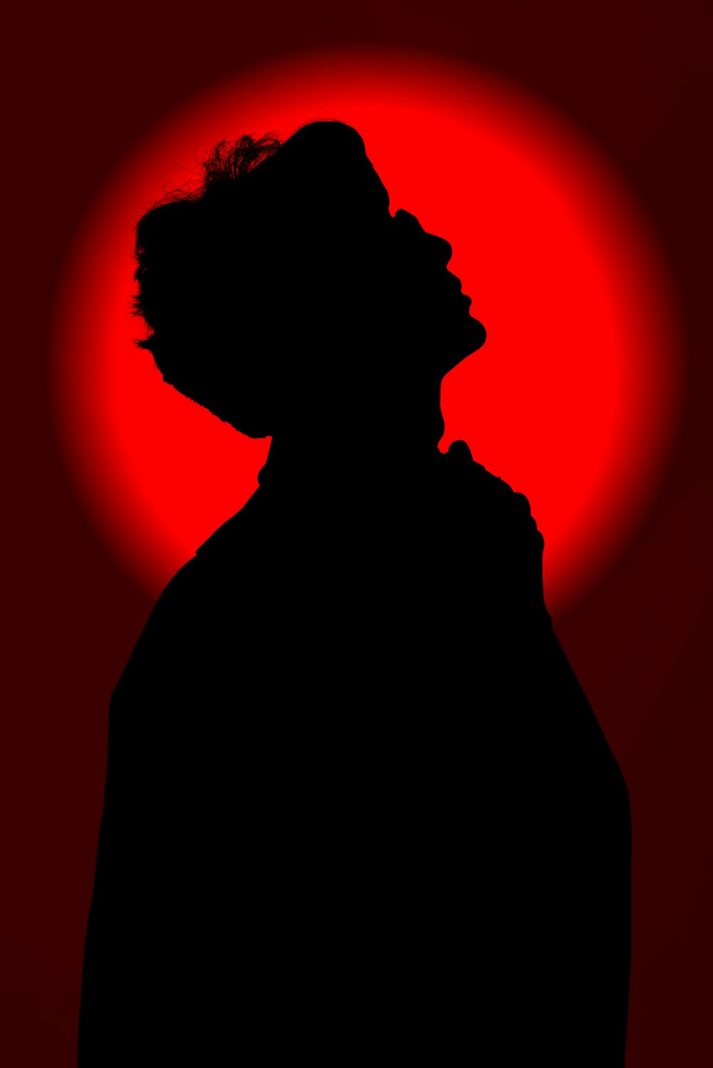 a silhouette of a man in front of a red sun