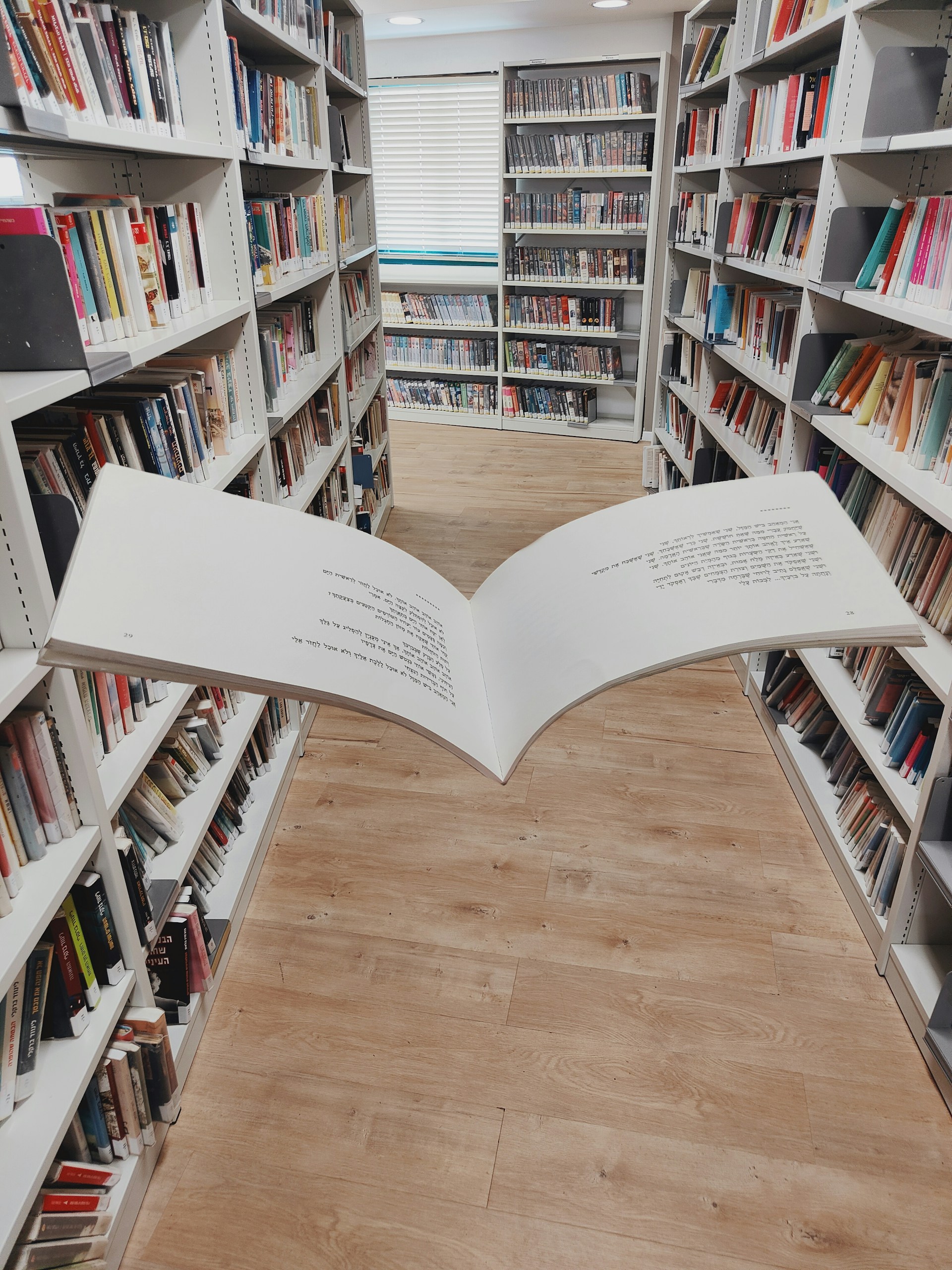 an open book on a wooden floor in a library