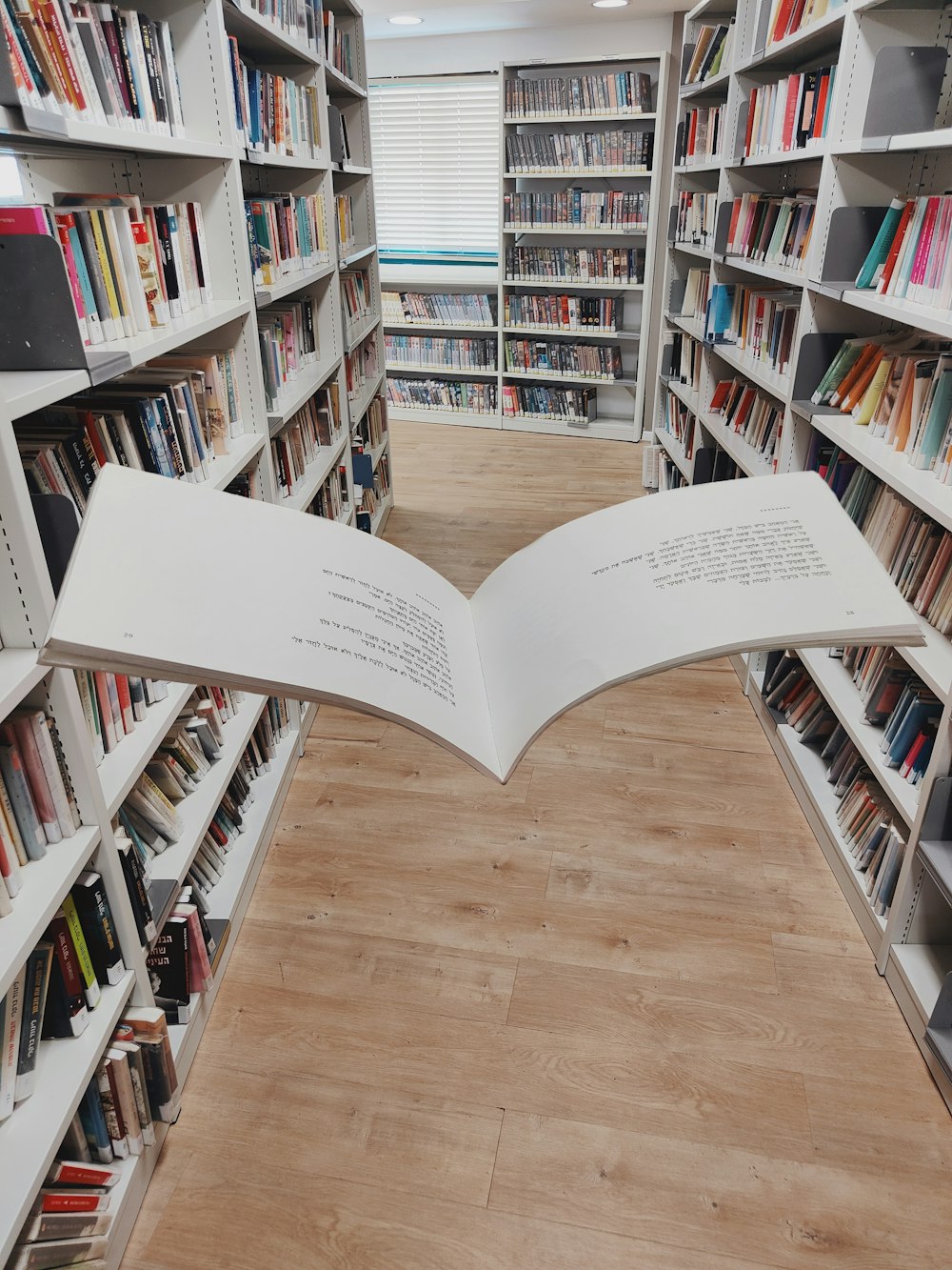 an open book on a wooden floor in a library