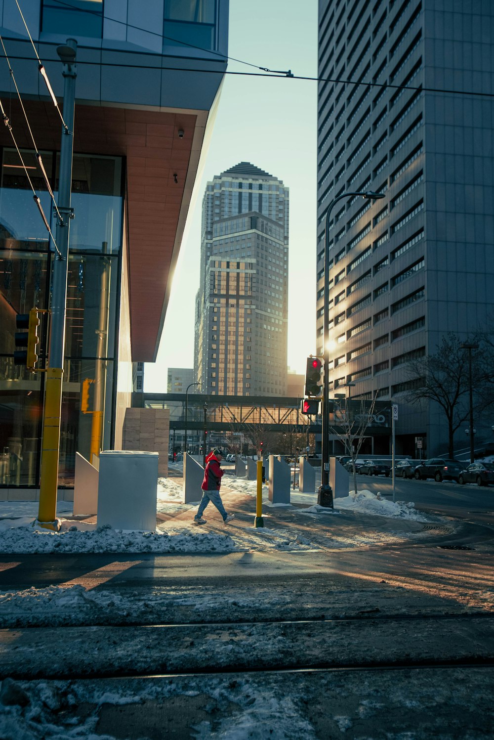 a man walking across a street next to tall buildings