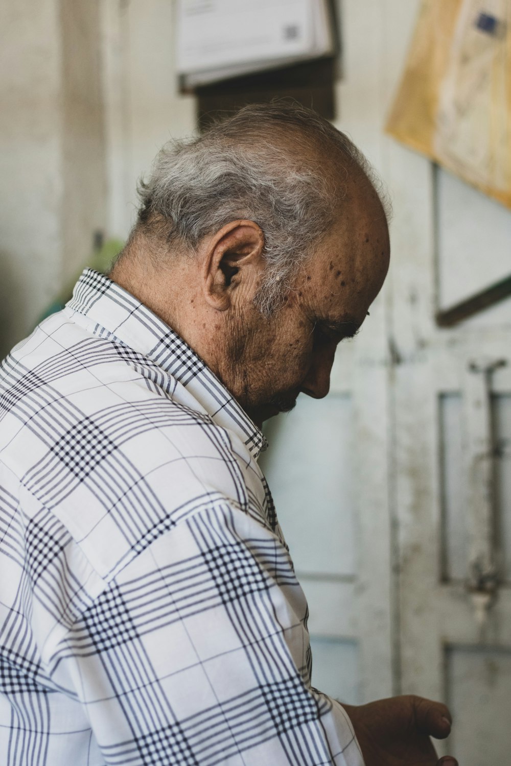 a man in a checkered shirt looking at a cell phone