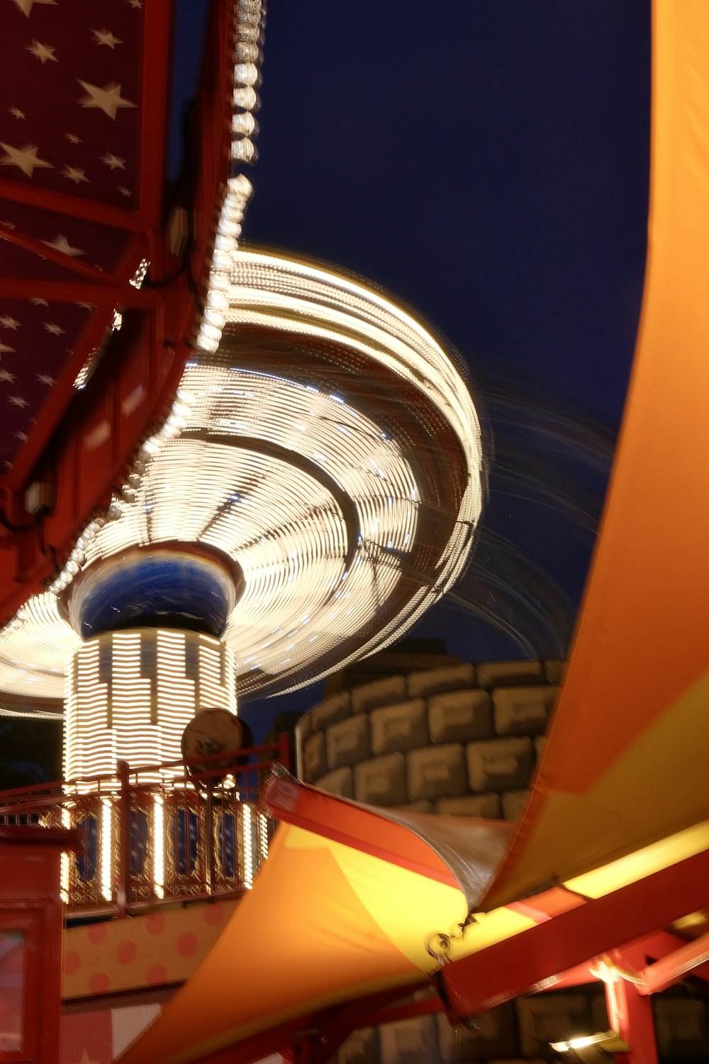 a carnival ride at night with a ferris wheel in the background