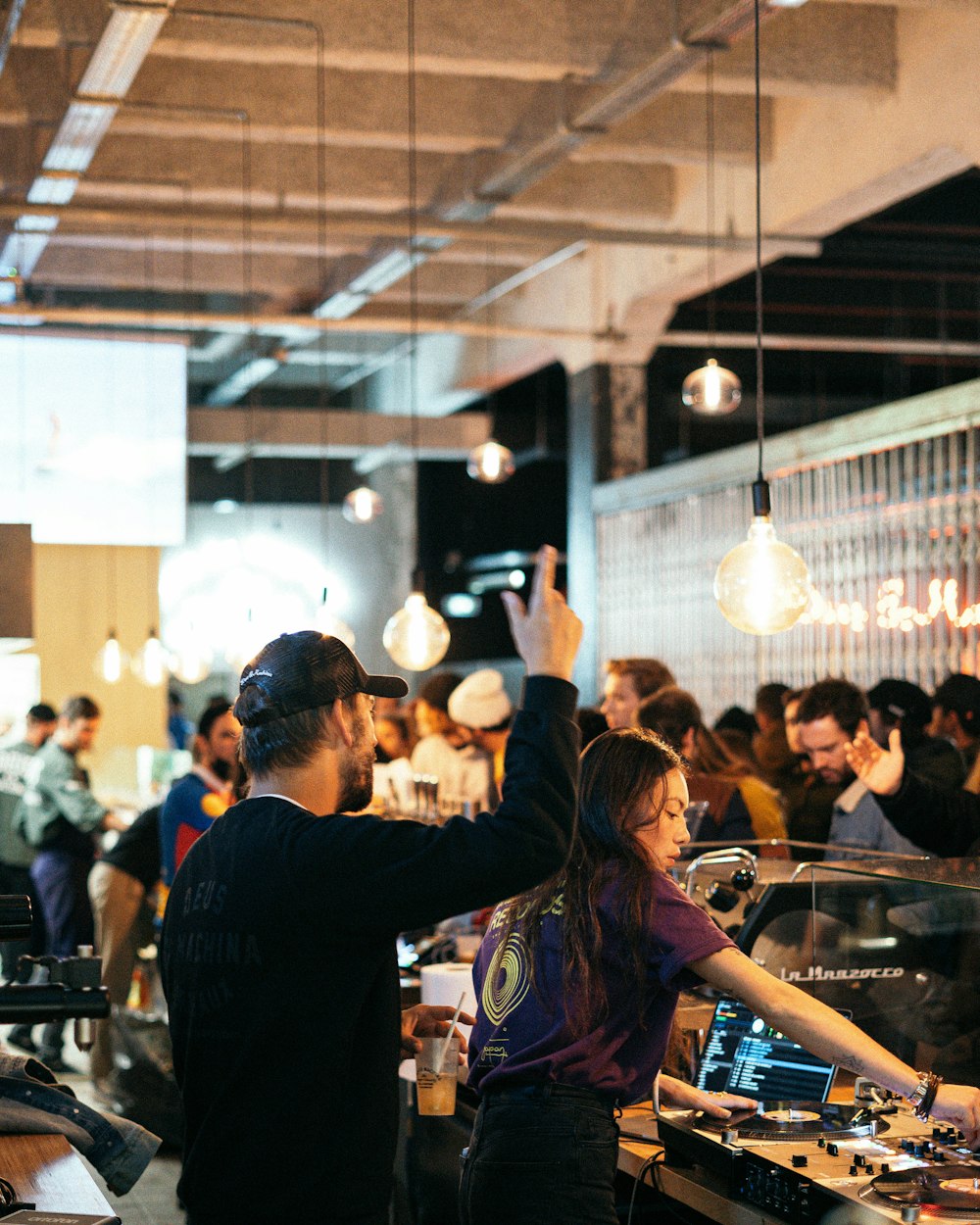 a group of people standing around a dj booth