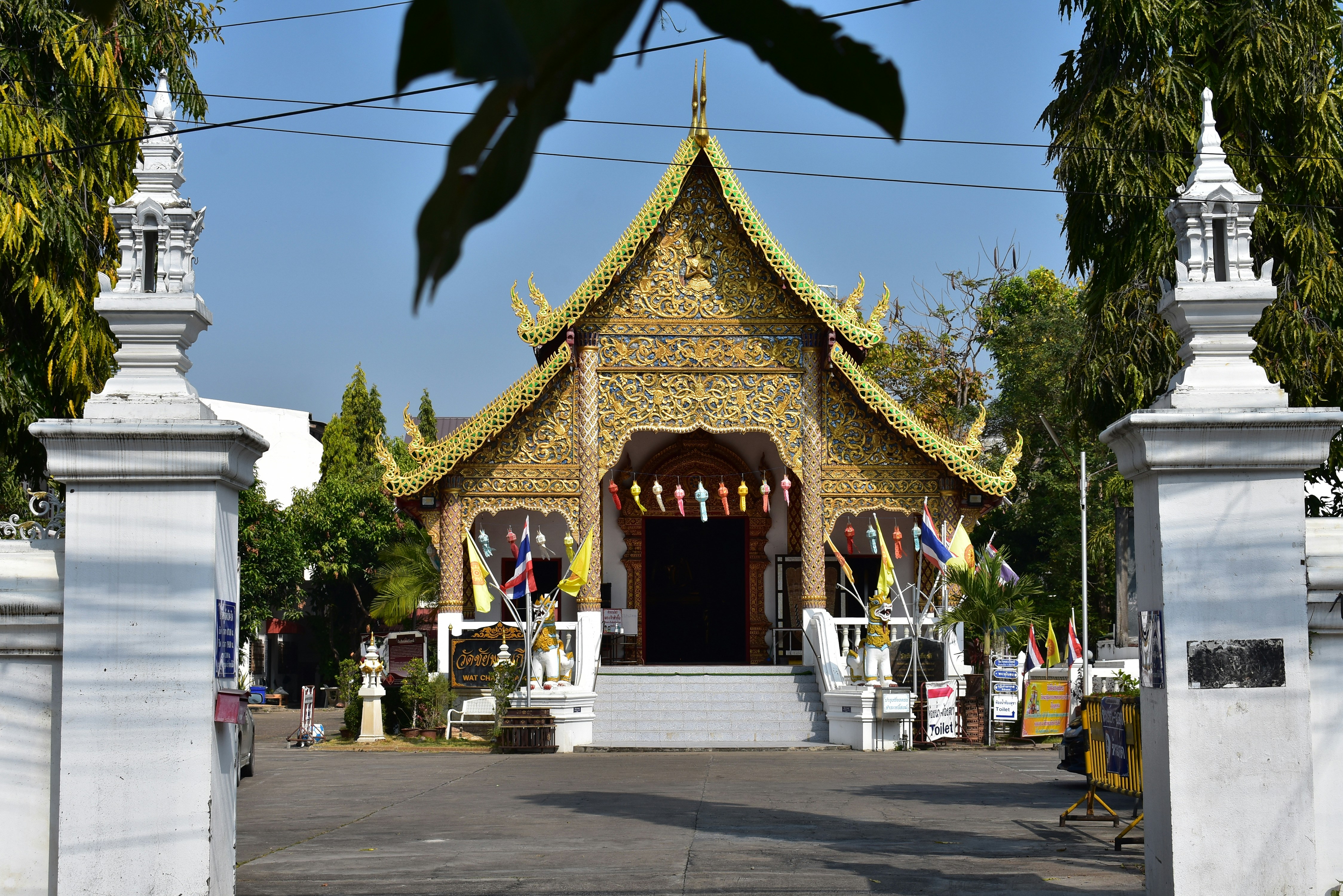 a white gate with a yellow and white building in the background