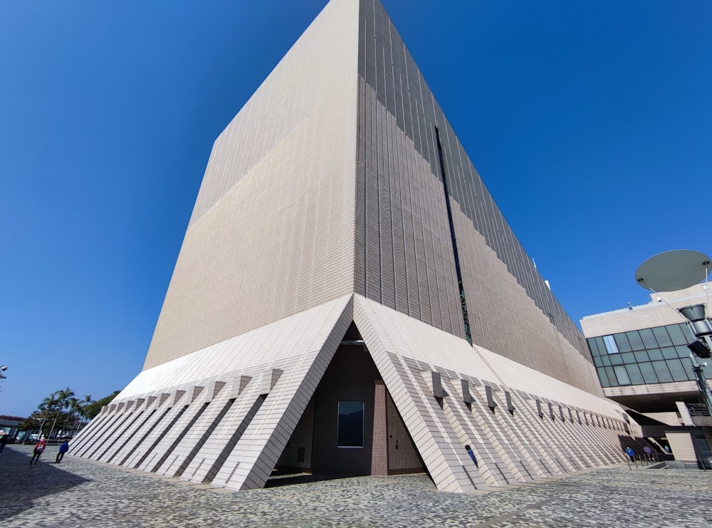 a large triangular building with a sky background